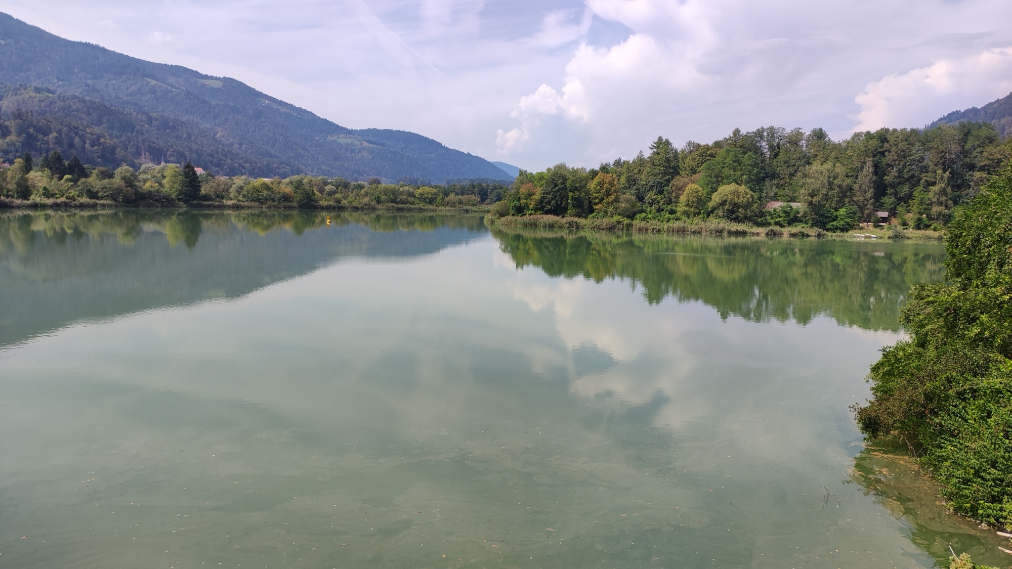 Lake Dravograd seen from Črneče, between wooded mountains